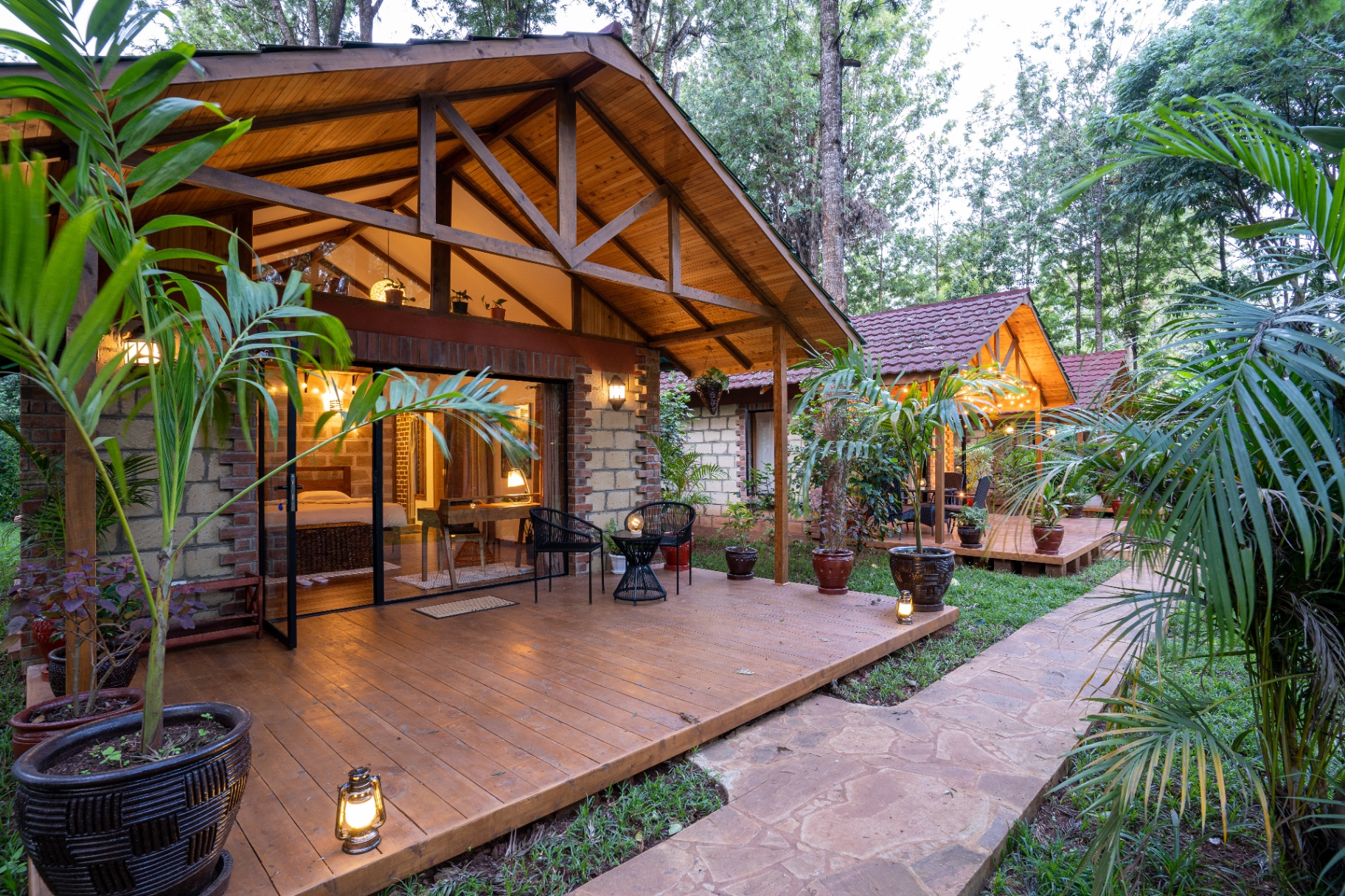 Private cottage with wooden deck glowing at dusk in the jungle